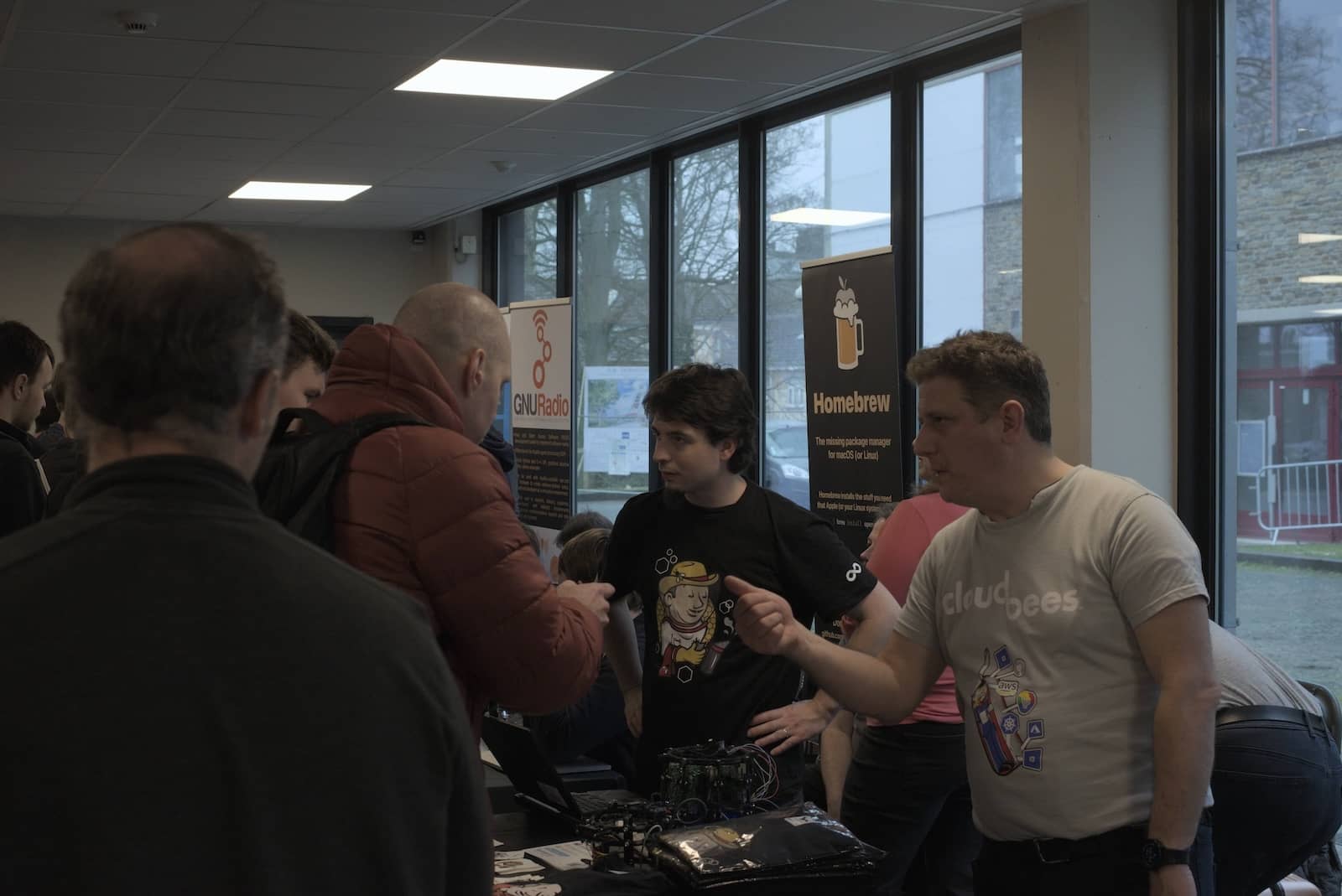 Damien Duportal and Stephane Merle converse with guests to the Jenkins booth at FOSDEM.